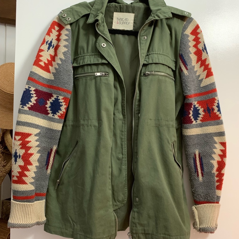 Army green jacket with sweater sleeves.